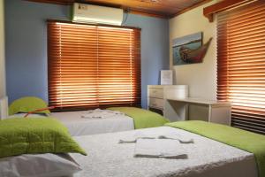 um quarto com 2 camas, uma secretária e janelas em Escalona's place em San Andrés