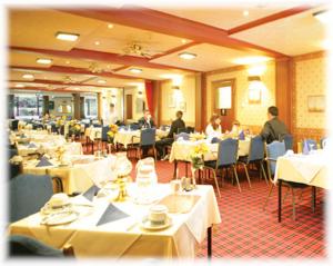 Willowbank Hotel في لارغس: مطعم بالطاولات البيضاء والناس جالسين على الطاولات