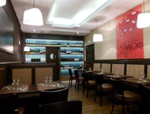 a restaurant with tables and chairs and a wine cellar at Hôtel Victor in Beauvais