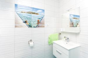 Un baño blanco con lavabo y espejo. en Apartments Summertime, en Srima 35 fotos más