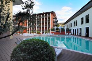 basen w budynku z krzesłami i budynek w obiekcie Club Hotel e Residence La Vela w orbole