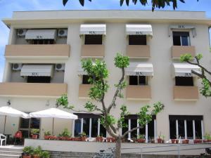 a large white building with umbrellas in front of it at Hotel Naviglio in Marina di Pietrasanta