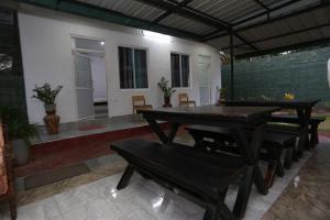 a patio with a wooden table and benches at Araliya White House in Negombo