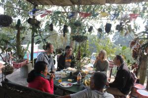 a group of people sitting around a table at Mansarover Home Stay in Kalimpong