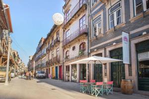 a street with tables and an umbrella in front of a building at Flowerstreet54 in Porto