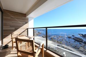 een kamer met een balkon met uitzicht op de oceaan bij Shiosai Resort Kamogawa in Kamogawa