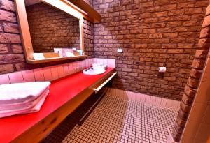 a bathroom with a sink and a brick wall at Flinders Cove Motel in Flinders