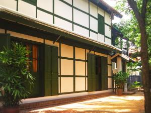 ein Gebäude mit grüner und weißer Farbe darauf in der Unterkunft Maison Houng Chanh - Luang prabang in Luang Prabang