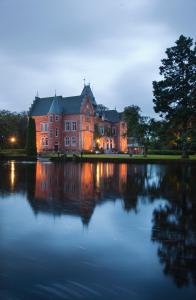 a large house sitting on top of a lake at Thorskogs Slott in Västerlanda