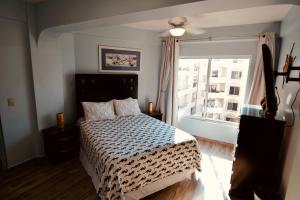 a bedroom with a bed and a large window at Maz4you Beachfront Condo in Mazatlán +42 photos