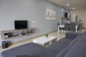 un soggiorno con 2 divani blu e una TV di PM Octagon Ipoh Suites & Apartment 1 a Ipoh