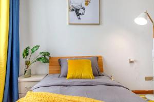 - une chambre avec un lit et un oreiller jaune dans l'établissement Henan Kaifeng·Henan University· Locals Apartment 00170030, à Kaifeng