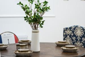 a table with a vase with a plant in it at Chengdu Qingyang·Kuanzhai Alley· Locals Apartment 00170590 in Chengdu