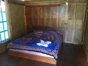 a bedroom with a bed in a wooden room at Eka's Bungalows in Maninjau