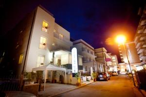 a building with a sign in front of it at night at Hotel Marina Bay in Rimini