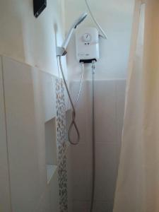 um chuveiro na casa de banho com uma cortina de chuveiro em Sand 1 Hostel em Siquijor