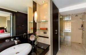 a bathroom with a sink and a shower and a toilet at Ramada Plaza by Wyndham Bangkok Menam Riverside in Bangkok