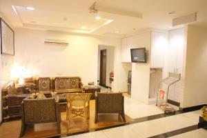 a living room with a couch and chairs and a tv at N K Hotel in Muar
