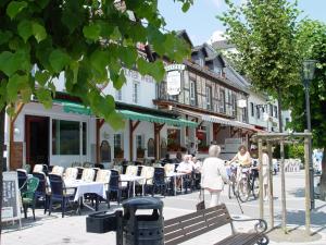 eine Gruppe von Personen, die vor einem Restaurant an Tischen sitzen in der Unterkunft Hotel Vater Rhein in Bad Breisig