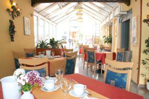 ein Restaurant mit Tischen und Stühlen mit rotem Tischtuch in der Unterkunft Hotel Vater Rhein in Bad Breisig