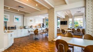 cocina y comedor con mesas y sillas en Best Western Plus Yacht Harbor Inn, en Dunedin