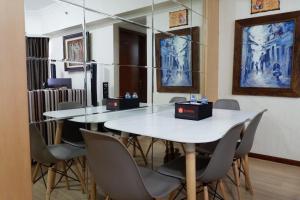 a dining room with a white table and chairs at 3BR Apartment at Sudirman Condominum Tower By Travelio in Jakarta