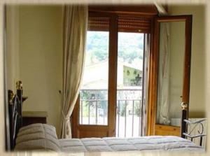 a bedroom with a bed and a large window at Apartamentos Los Hebiles in Jerte
