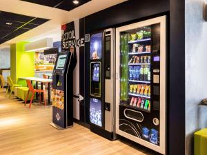 a soda vending machine in a restaurant with a table at ibis budget Meudon Paris Ouest in Meudon