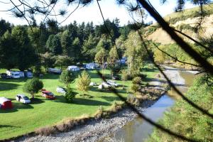 Blick auf einen Park mit Zelten und einen Fluss in der Unterkunft Riverside Haven Lodge & Holiday Park in Waianakarua