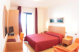 a bedroom with a red bed and a chair at Hotel Yria in Vieste