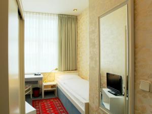 a hotel room with a bed and a television at Hotel Bellmoor im Dammtorpalais in Hamburg