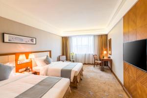 Postel nebo postele na pokoji v ubytování Wan Yue Grand Skylight Hotel