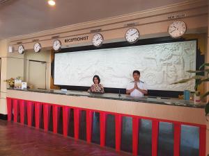dos personas de pie detrás de una barra con una pantalla grande en The K Hotel en Nagoya