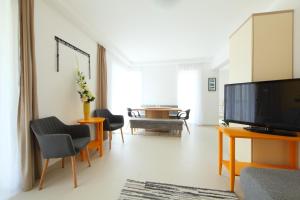 a living room with a flat screen tv and a table at Gorazd Nyaralóház in Balatonfüred