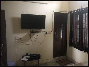 Habitación con TV de pantalla plana en la pared en Hotel Dharohar Palace en Jaipur