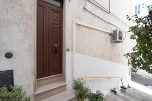 una porta su un edificio con piante sui gradini di La Cupoletta a Ostuni