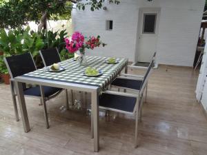 a table with chairs and flowers on a patio at Cozy Citrus Garden House by the Seaside. in Khónai
