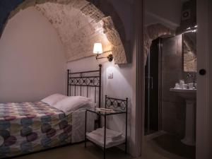 ein Schlafzimmer mit einem Bett und einem Waschbecken in einem Zimmer in der Unterkunft Terrazza Sui Trulli in Alberobello