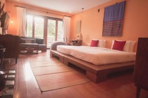 a bedroom with a bed and a couch and a window at iRoHa Garden Hotel & Resort in Phnom Penh