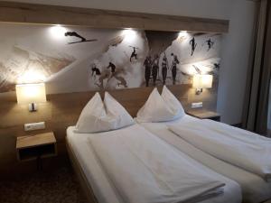 ein Hotelzimmer mit einem großen Bett mit zwei Lampen in der Unterkunft Lammertalerhof in Abtenau