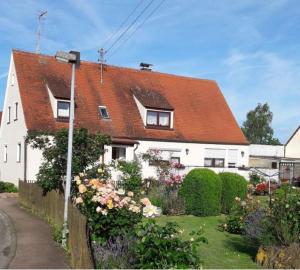 una casa bianca con il tetto rosso di Ferienwohnung Irmgard a Nördlingen