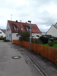 a house with a orange fence next to a street at Ferienwohnung Irmgard in Nördlingen