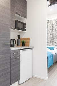 een keuken met een koelkast en een bed in een kamer bij Oma Hotelli in Ylöjärvi