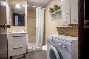 a bathroom with a washing machine and a sink at Homenfun Baqueira-Beret Vielha in Vielha