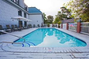 uma piscina com água azul num quintal em The Bellmoor Inn and Spa em Rehoboth Beach