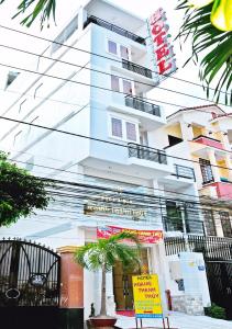 een wit gebouw met een bord ervoor bij Hoang Thanh Thuy Hotel 1 in Ho Chi Minh-stad