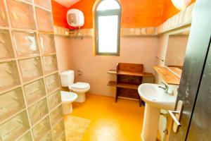 a small bathroom with a toilet and a sink at Surfactivity Guest House in Santa Maria