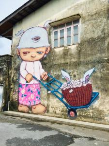 a painting of a doll pushing a cart with a basket of eggs at Phuket Sunny Hostel in Phuket Town