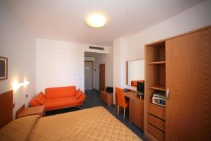 una camera con letto, scrivania e sedia di Hotel Yria a Vieste