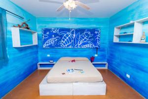 a blue room with a bed with a blue wall at Surfactivity Guest House in Santa Maria